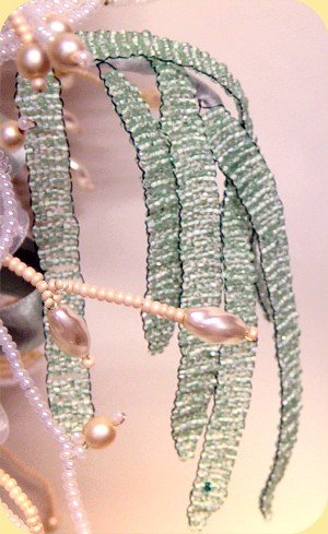 dettaglio bouquet perline sposa, rametto di foglie verdi ad intreccio di conterie particolari
