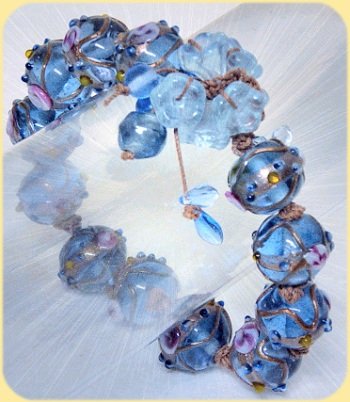 bracciale di perle e fili cerati intrecciati chiusura asola con fiorellini di vetro